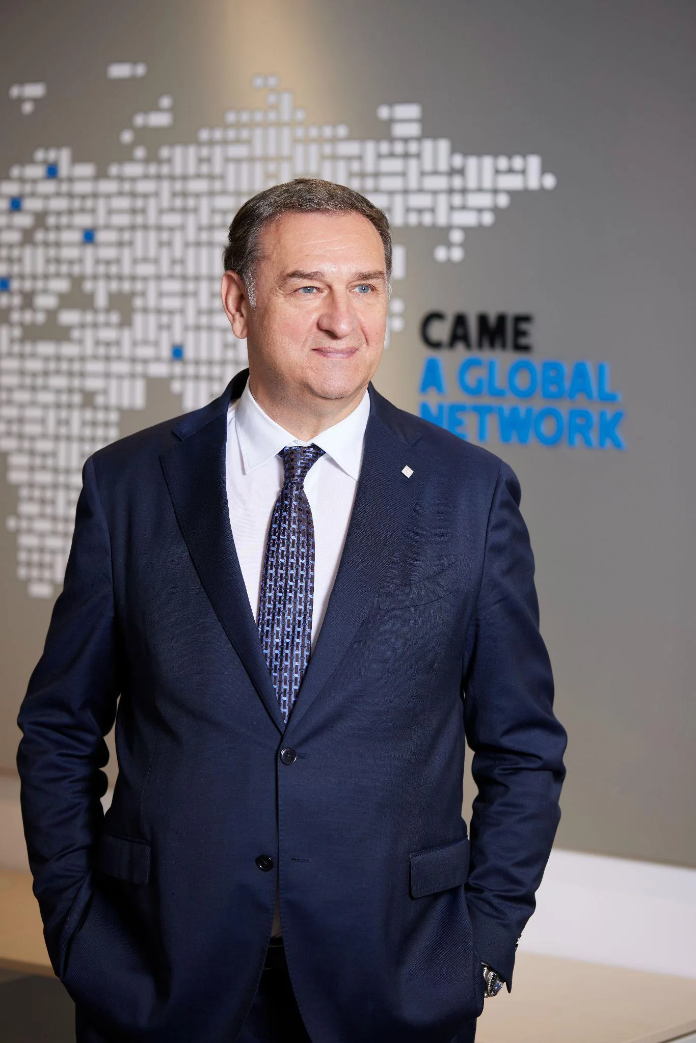 Portrait du Directeur Général de CAME France devant la carte du réseau mondial — branding intégré au décor